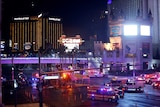 Emergency vehicles with lights on crowd a road intersection near the Mandalay Bay hotel.