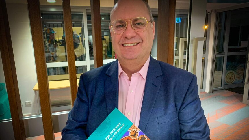 Man holding Dhurga dictionary ,smiling