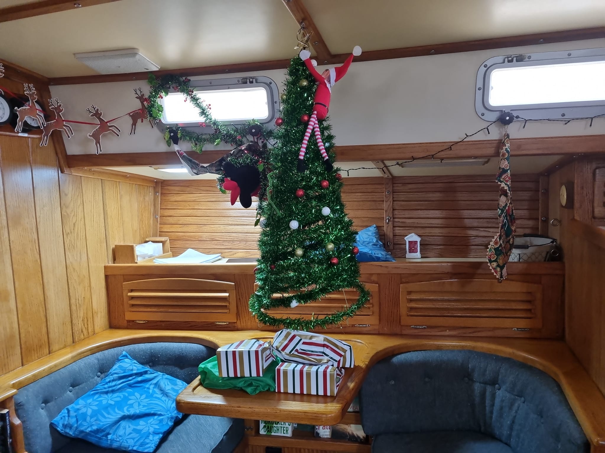Picture of a Christmas tree and presents in the cockpit of a boat. 