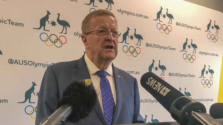 John Coates stands in front of a lecturn and speaks.