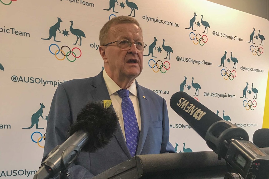 John Coates stands in front of a lecturn and speaks.