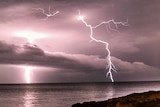Lightning forks over the ocean.