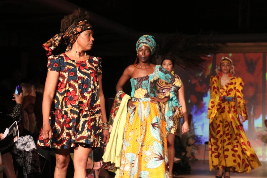 Models wearing brightly coloured outfits on a catwalk.