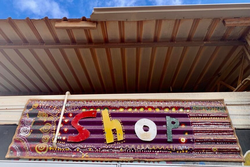 波纹铁皮上的艺术标牌上写着“商店”