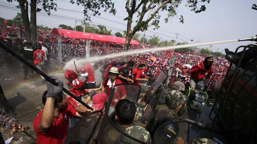 Thai army soldiers fire a water cannon at anti-government red shirt protesters