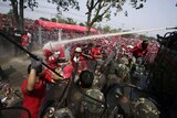 Thai army soldiers fire a water cannon at anti-government red shirt protesters
