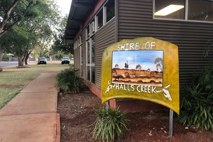 A colourful, hand-painted sign out the front of a building that says "Shire of Halls Creek".