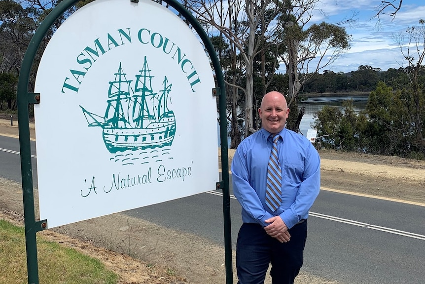 Tasman Mayor Kelly Spaulding stands next to a sign.