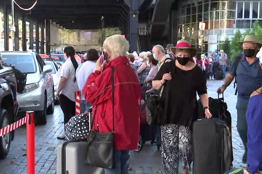 A line of people waiting for taxis 