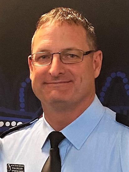 A male police officer smiling at the camera.