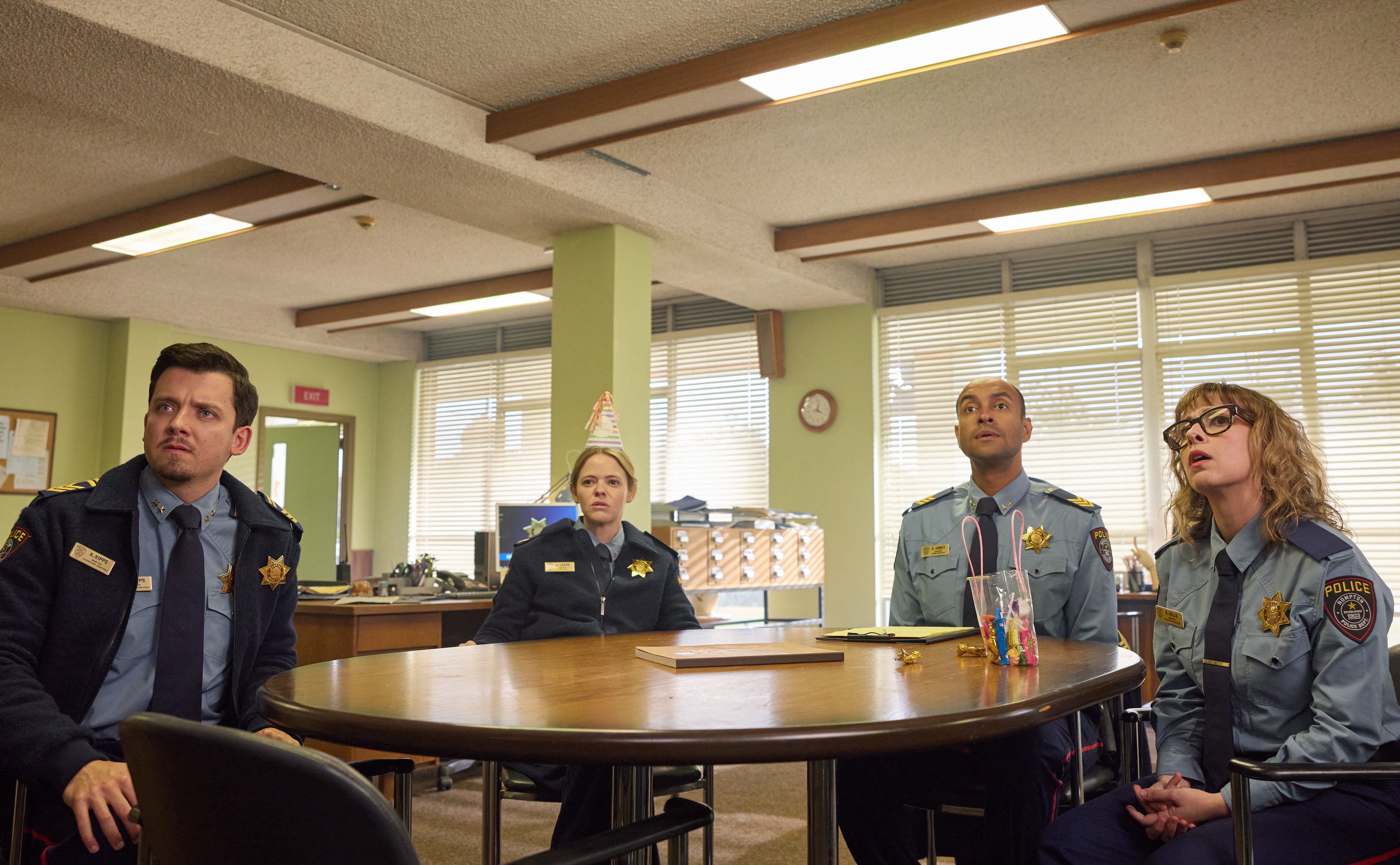 Police officers sit around a table