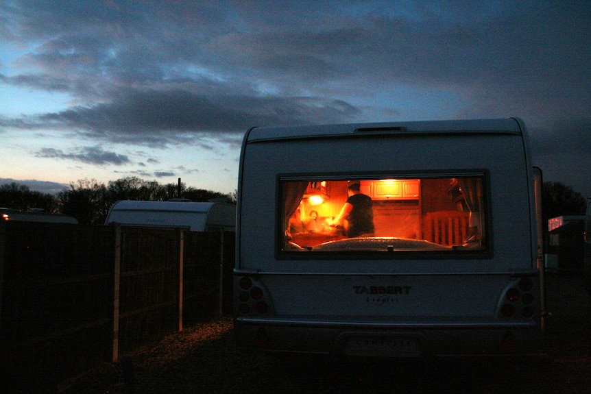 The light shines out of a caravan at night