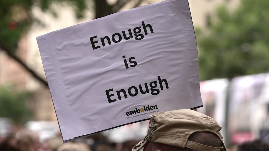 A paper sign reading 'enough is enough'.