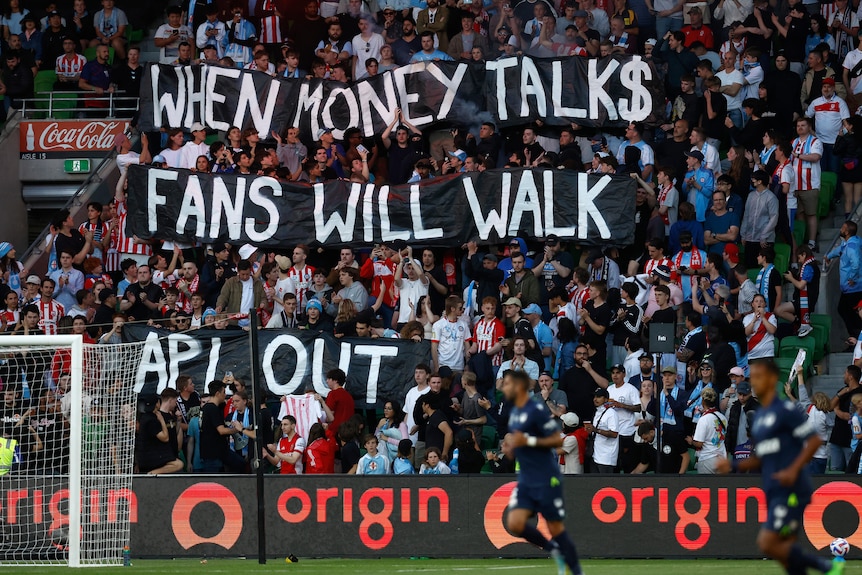 Spectators hold up banners at an A-League Men match in Melbourne.