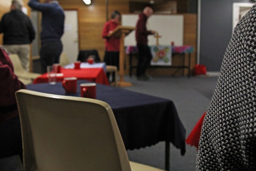 Photo peering over a mans shoulder inside a neighbourhood centre.