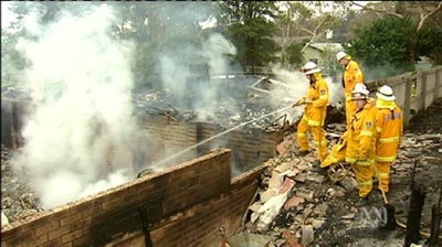 Firefighters mop up after fire destroyed homes on the NSW Central Coast.