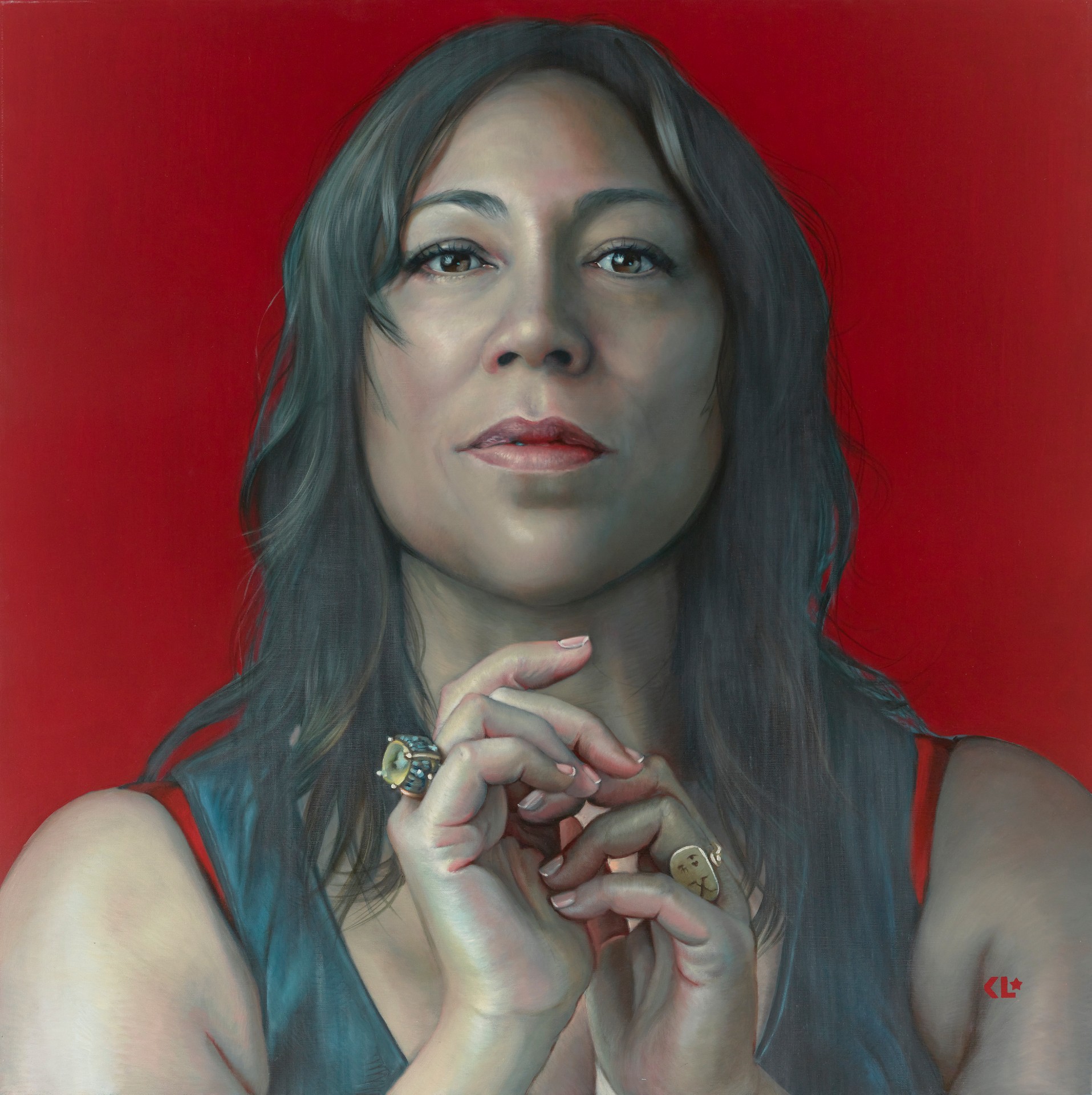 A portrait of Kate Ceberano with her chin slightly raised and hands in front of her chest