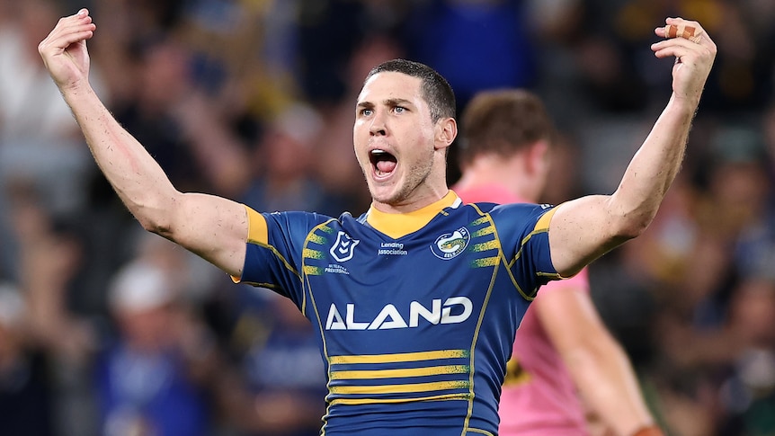 A Parramatta Eels NRL player raises his arms as he celebrates defeating Penrith Panthers.