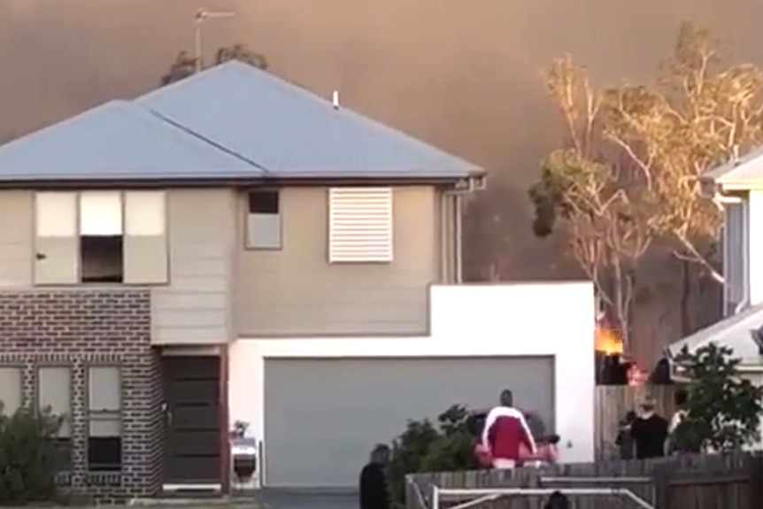 Flames right behind a suburban house at Peregian Springs.