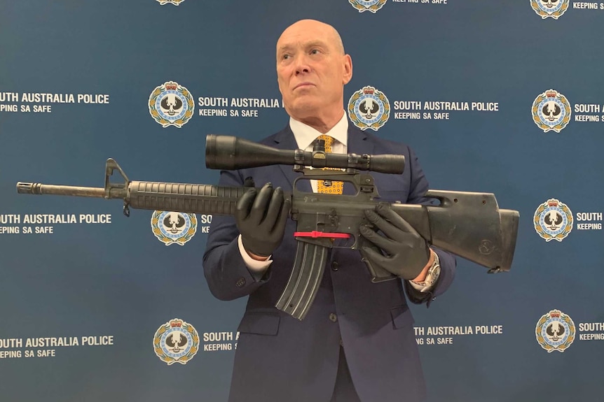 A policeman holding an automatic rifle.