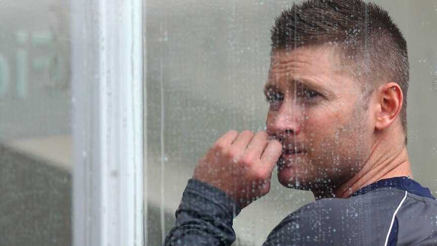 Under the weather: An anxious Michael Clarke watches a vital day go down the drain.