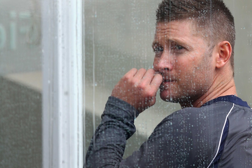 Under the weather: An anxious Michael Clarke watches a vital day go down the drain.