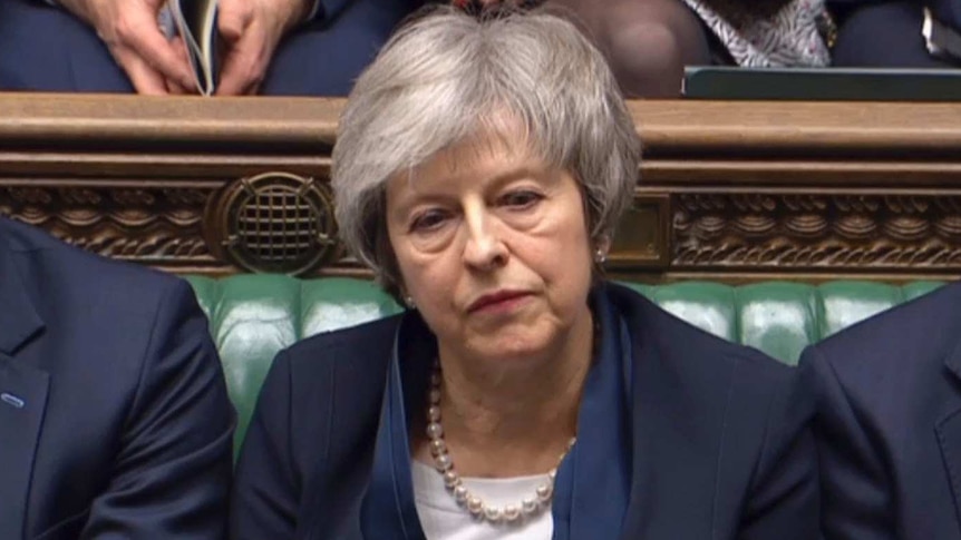 Theresa May sits with a stern face in British Parliament