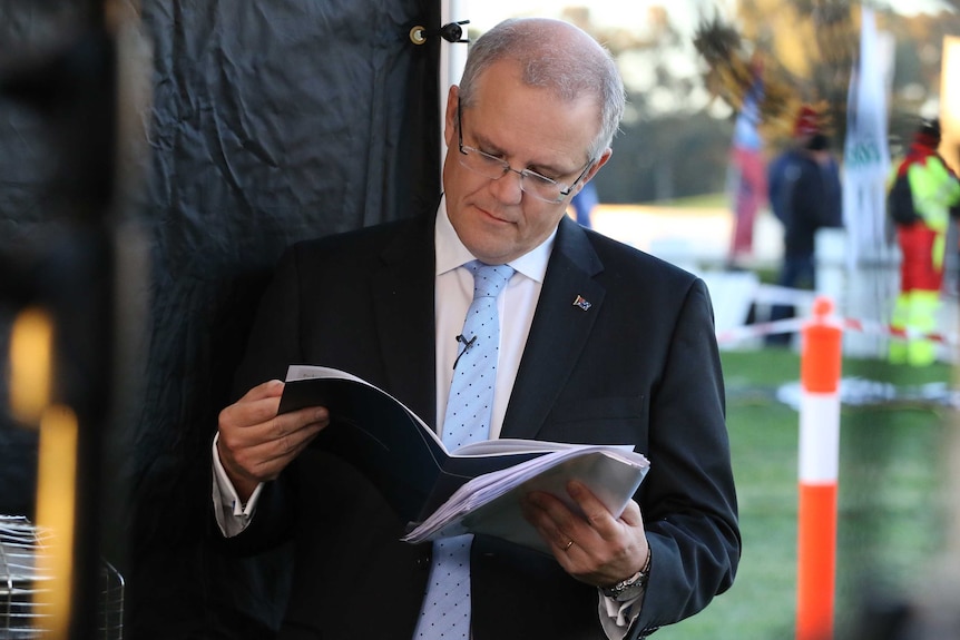 Treasurer Scott Morrison reads the 2017 federal budget.