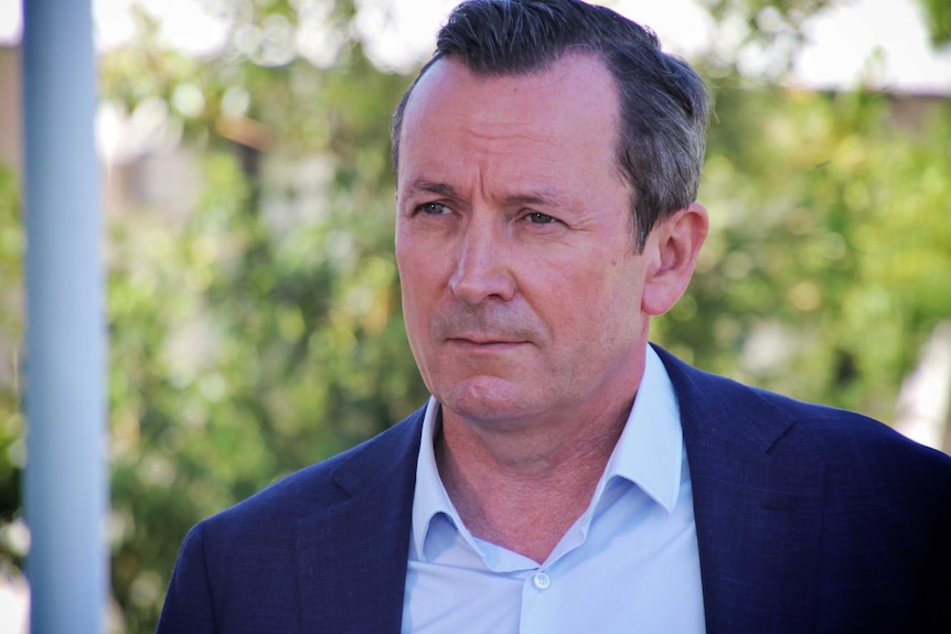 A close up of Mark McGowan wearing a blue suit, standing outside.