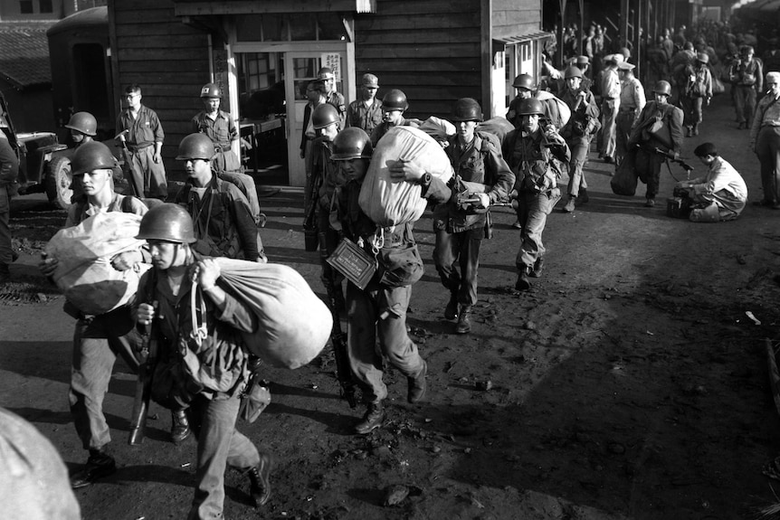 American foot soldiers leave the railroad station at Taejon, South Korea