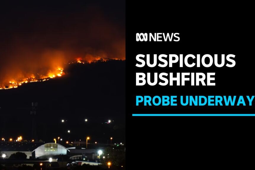 Suspicious Bushfire, Probe Underway: A bushfire lights up a ridge over a township at night.