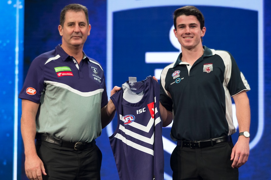 Le joueur des Fremantle Dockers Andrew Brayshaw tient son maillot avec l'ancien entraîneur Ross Lyon le soir du repêchage en 2017