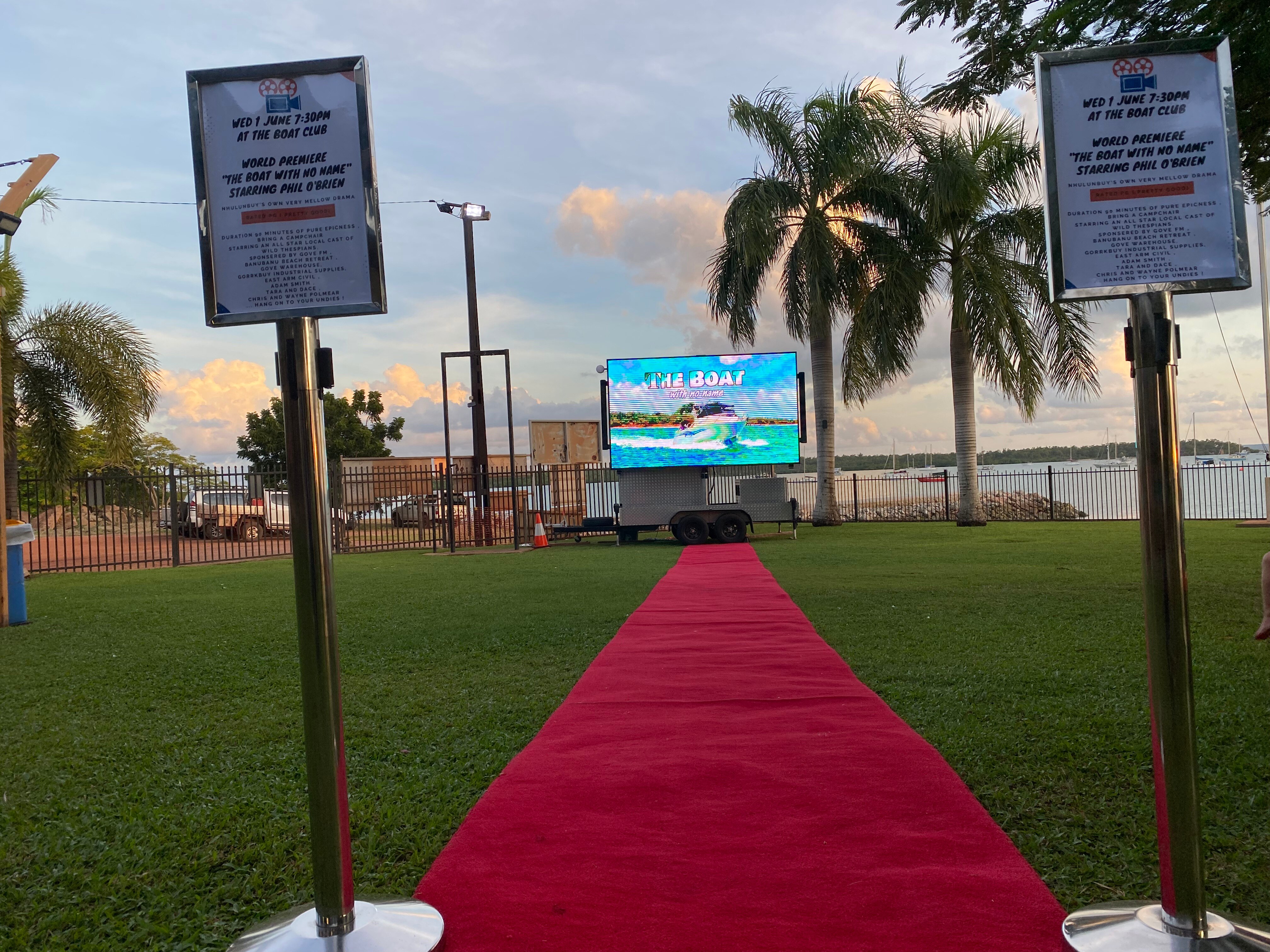 red carpet rolled out on grass near a beach