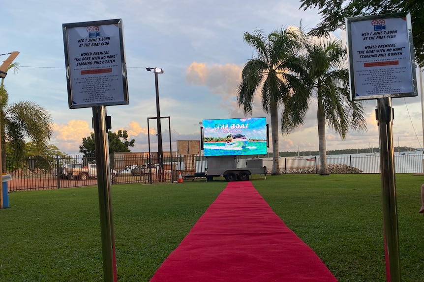 red carpet rolled out on grass near a beach
