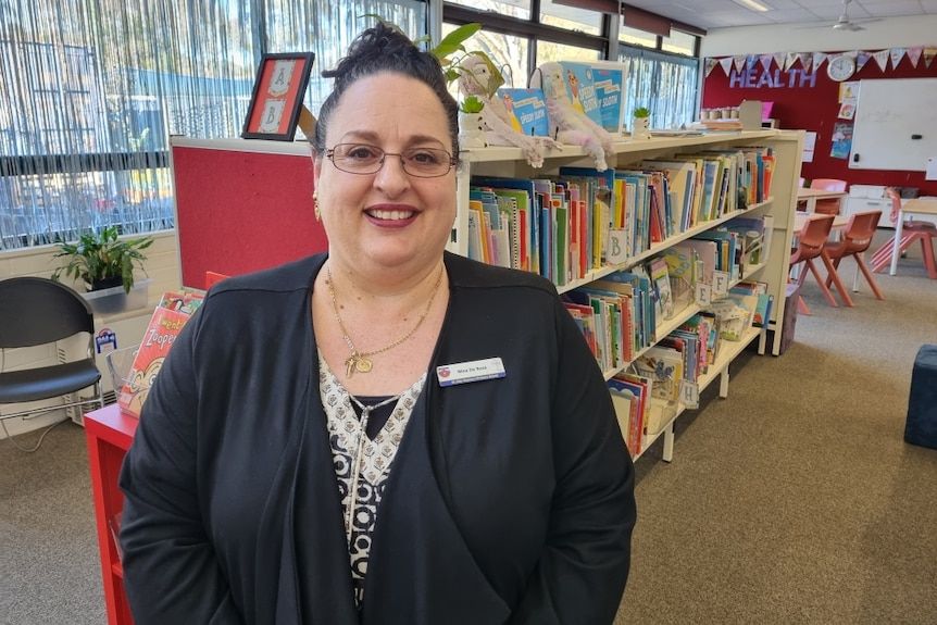 A woman stands in a primary school library.