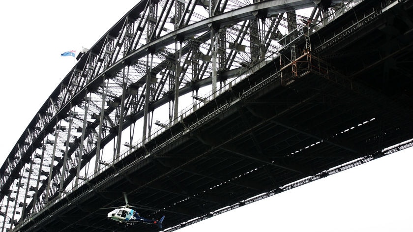 Search and rescue: A police helicopter flies under the Sydney Harbour Bridge.