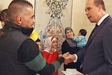 Minister for Immigration and Border Protection, Peter Dutton, presents refugee visas to Syrian and Iraqi families.