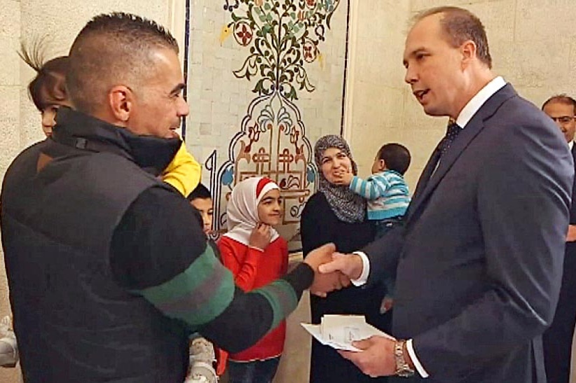 Minister for Immigration and Border Protection, Peter Dutton, presents refugee visas to Syrian and Iraqi families.