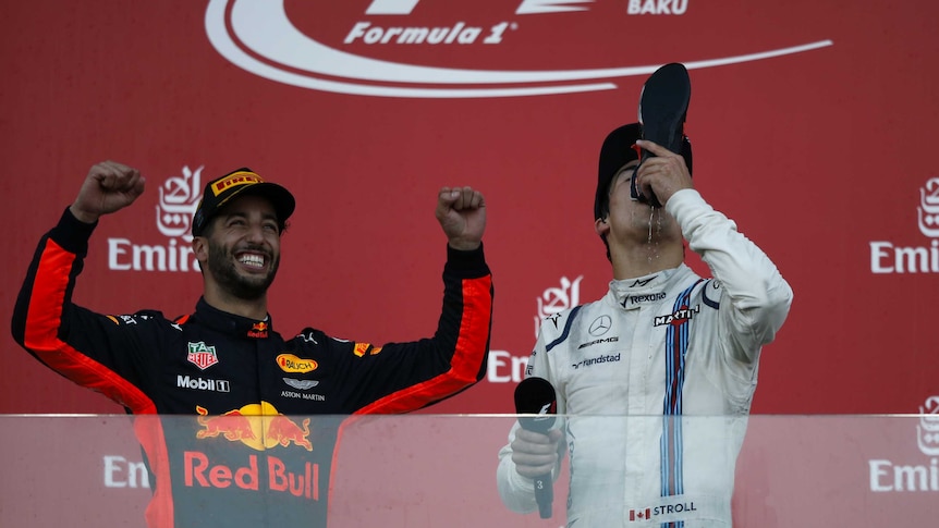 Lance Stroll does a shoey from the boot of Daniel Ricciardo in the podium in Baku.