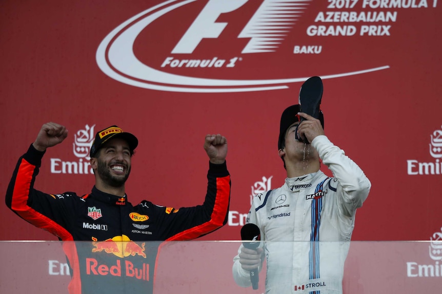 Lance Stroll does a shoey from the boot of Daniel Ricciardo in the podium in Baku.