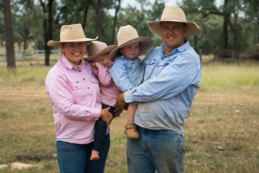 Photo of a woman and man holding two children.