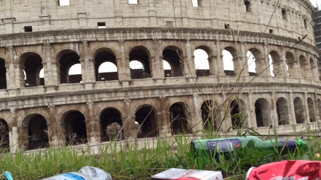 Trash litters the grass outside the colosseum in Rome