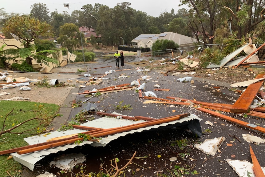 A suburban street strewn with large debris.