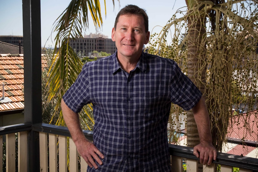 Tony Brown stands on a veranda.