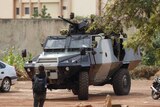 Presidential guard soldiers are seen on an armoured vehicle at Laico hotel in Ouagadougou