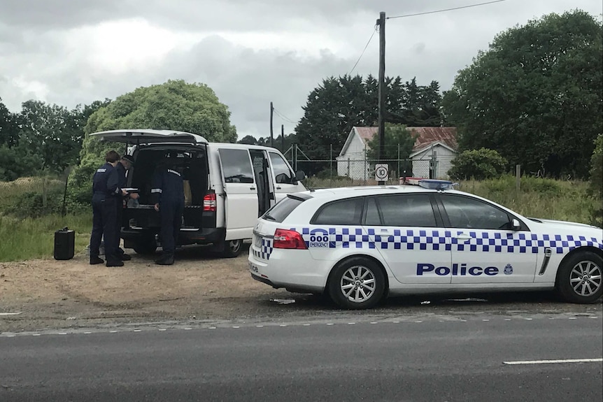 Victoria Police officers and vehicles at a Tyabb property where a body was found.