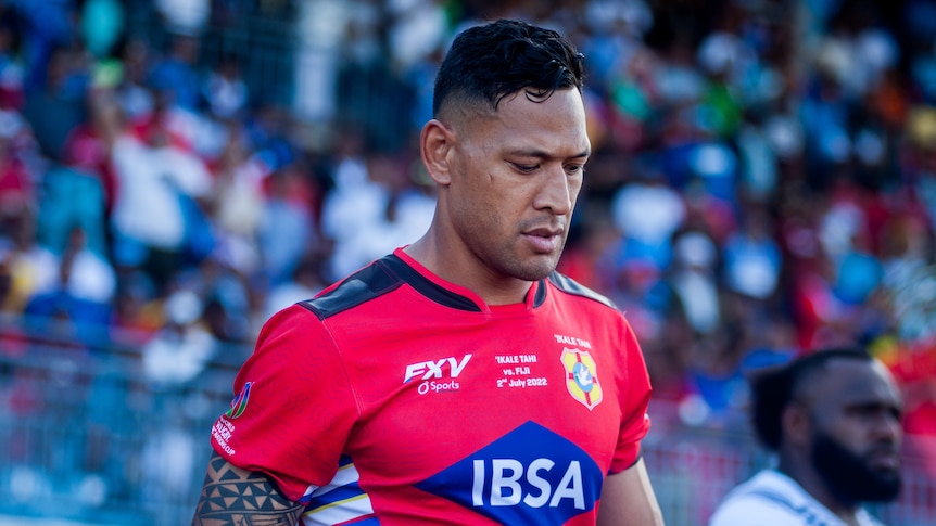 A Tongan male rugby international walks onto the field against Fiji.