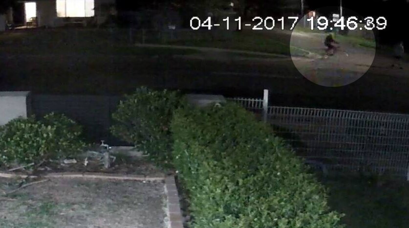 A bicycle riding at night captured from a front yard camera.