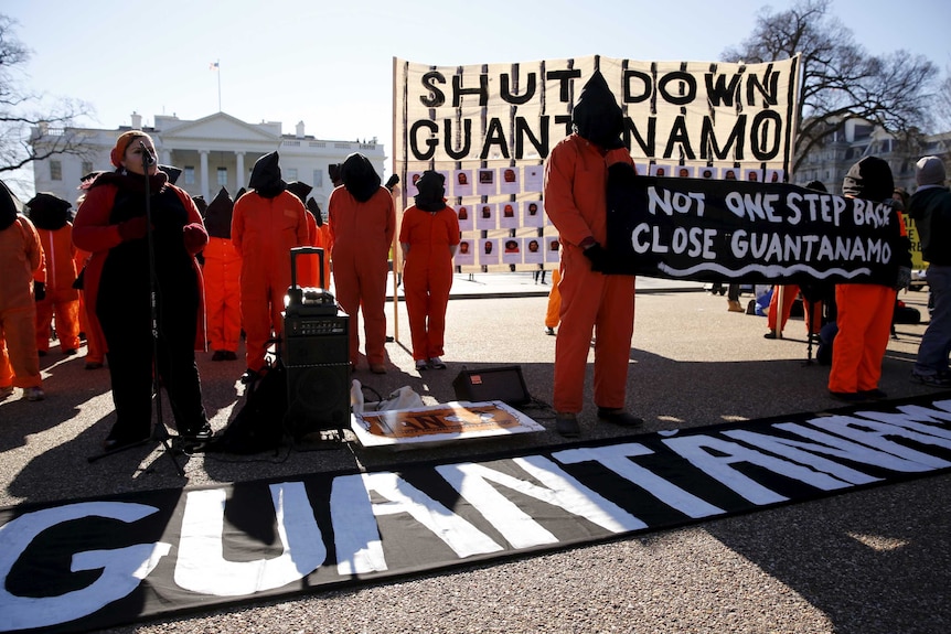 Protesters in orange jumpsuits from Amnesty International US