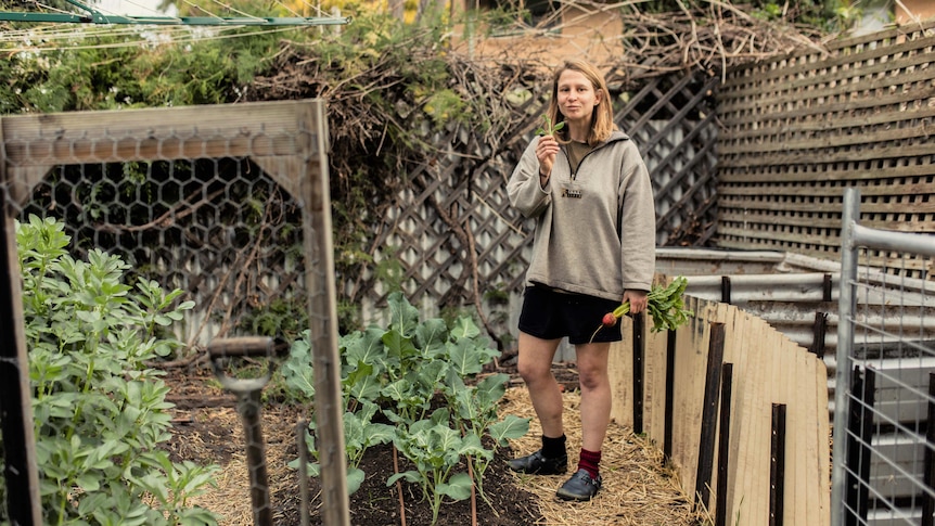 Brooklyn Mabbott stands in her garden surrounded by vegetable boxes 